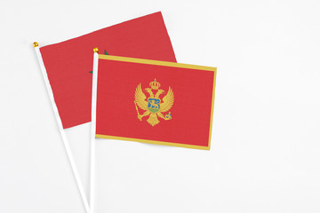 Montenegro and Morocco stick flags on white background. High quality fabric, miniature national flag. Peaceful global concept.White floor for copy space.