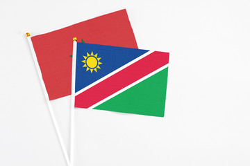 Namibia and Morocco stick flags on white background. High quality fabric, miniature national flag. Peaceful global concept.White floor for copy space.