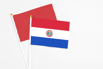 Paraguay and Morocco stick flags on white background. High quality fabric, miniature national flag. Peaceful global concept.White floor for copy space.