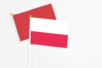 Poland and Morocco stick flags on white background. High quality fabric, miniature national flag. Peaceful global concept.White floor for copy space.