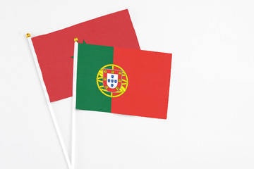 Portugal and Morocco stick flags on white background. High quality fabric, miniature national flag. Peaceful global concept.White floor for copy space.
