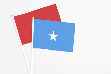 Somalia and Morocco stick flags on white background. High quality fabric, miniature national flag. Peaceful global concept.White floor for copy space.