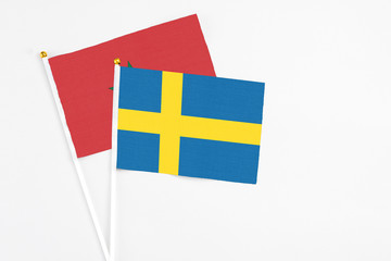 Sweden and Morocco stick flags on white background. High quality fabric, miniature national flag. Peaceful global concept.White floor for copy space.