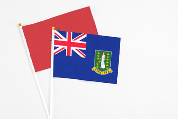 Fototapeta premium British Virgin Islands and Morocco stick flags on white background. High quality fabric, miniature national flag. Peaceful global concept.White floor for copy space.