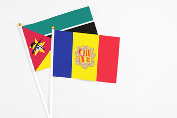 Andorra and Mozambique stick flags on white background. High quality fabric, miniature national flag. Peaceful global concept.White floor for copy space.