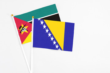 Fototapeta premium Bosnia Herzegovina and Mozambique stick flags on white background. High quality fabric, miniature national flag. Peaceful global concept.White floor for copy space.