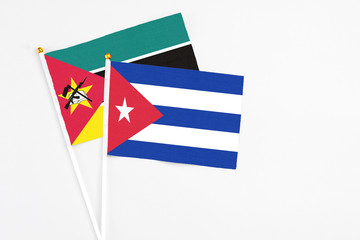 Cuba and Mozambique stick flags on white background. High quality fabric, miniature national flag. Peaceful global concept.White floor for copy space.