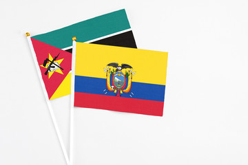 Ecuador and Mozambique stick flags on white background. High quality fabric, miniature national flag. Peaceful global concept.White floor for copy space.