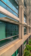 Fototapeta premium Vertical Office building exterior with close up on the glass windows and concrete wall