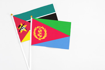 Eritrea and Mozambique stick flags on white background. High quality fabric, miniature national flag. Peaceful global concept.White floor for copy space.