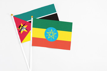 Ethiopia and Mozambique stick flags on white background. High quality fabric, miniature national flag. Peaceful global concept.White floor for copy space.