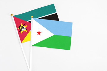 Djibouti and Mozambique stick flags on white background. High quality fabric, miniature national flag. Peaceful global concept.White floor for copy space.
