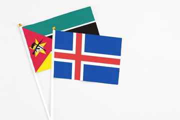 Iceland and Mozambique stick flags on white background. High quality fabric, miniature national...