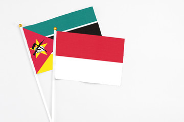 Indonesia and Mozambique stick flags on white background. High quality fabric, miniature national flag. Peaceful global concept.White floor for copy space.
