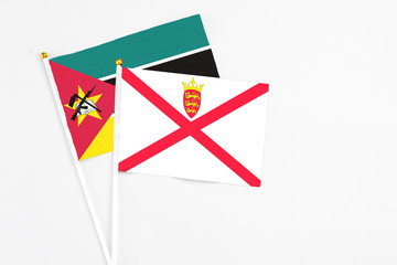 Jersey and Mozambique stick flags on white background. High quality fabric, miniature national...