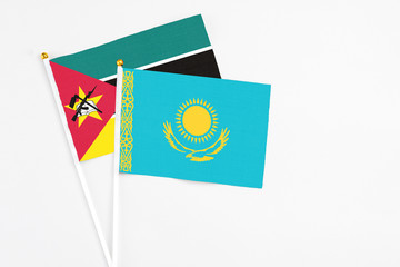 Kazakhstan and Mozambique stick flags on white background. High quality fabric, miniature national flag. Peaceful global concept.White floor for copy space.