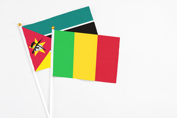 Mali and Mozambique stick flags on white background. High quality fabric, miniature national flag....