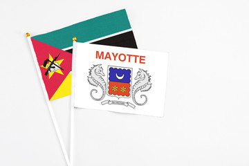 Mayotte and Mozambique stick flags on white background. High quality fabric, miniature national flag. Peaceful global concept.White floor for copy space.