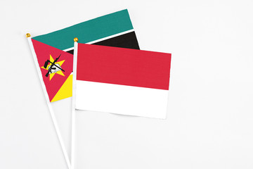 Monaco and Mozambique stick flags on white background. High quality fabric, miniature national...