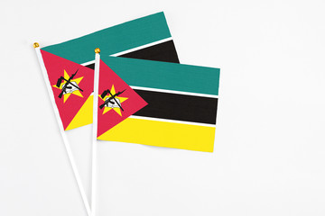Mozambique and Mozambique stick flags on white background. High quality fabric, miniature national flag. Peaceful global concept.White floor for copy space.