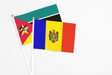 Moldova and Mozambique stick flags on white background. High quality fabric, miniature national flag. Peaceful global concept.White floor for copy space.