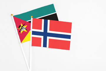 Norway and Mozambique stick flags on white background. High quality fabric, miniature national...