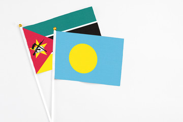 Palau and Mozambique stick flags on white background. High quality fabric, miniature national flag....