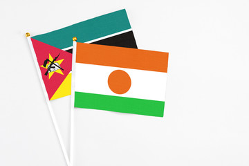 Niger and Mozambique stick flags on white background. High quality fabric, miniature national flag. Peaceful global concept.White floor for copy space.