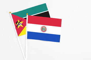 Paraguay and Mozambique stick flags on white background. High quality fabric, miniature national flag. Peaceful global concept.White floor for copy space.