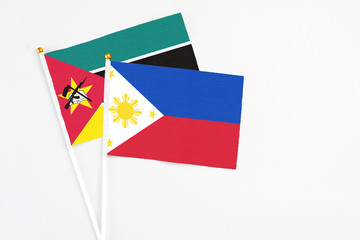 Philippines and Mozambique stick flags on white background. High quality fabric, miniature national flag. Peaceful global concept.White floor for copy space.
