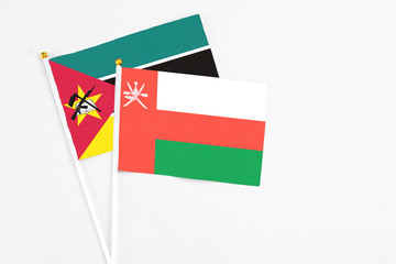 Oman and Mozambique stick flags on white background. High quality fabric, miniature national flag....