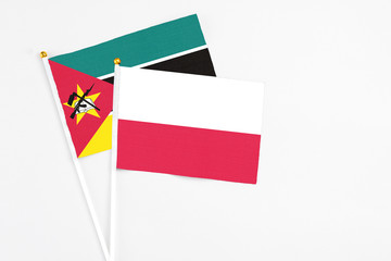 Poland and Mozambique stick flags on white background. High quality fabric, miniature national...