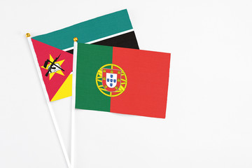 Portugal and Mozambique stick flags on white background. High quality fabric, miniature national flag. Peaceful global concept.White floor for copy space.