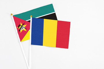 Romania and Mozambique stick flags on white background. High quality fabric, miniature national flag. Peaceful global concept.White floor for copy space.
