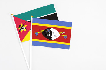 Swaziland and Mozambique stick flags on white background. High quality fabric, miniature national flag. Peaceful global concept.White floor for copy space.