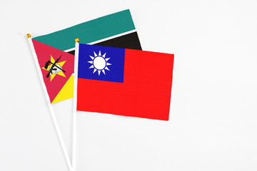 Taiwan and Mozambique stick flags on white background. High quality fabric, miniature national flag. Peaceful global concept.White floor for copy space.