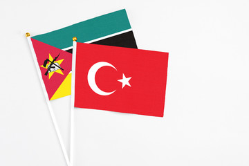 Turkey and Mozambique stick flags on white background. High quality fabric, miniature national flag. Peaceful global concept.White floor for copy space.