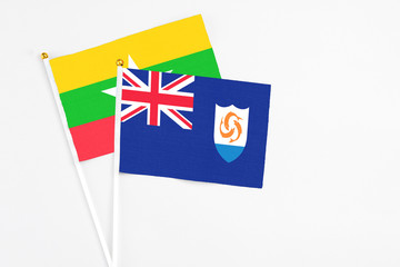 Fototapeta premium Anguilla and Myanmar stick flags on white background. High quality fabric, miniature national flag. Peaceful global concept.White floor for copy space.