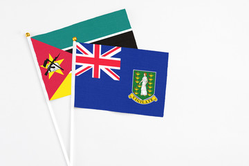 Fototapeta premium British Virgin Islands and Mozambique stick flags on white background. High quality fabric, miniature national flag. Peaceful global concept.White floor for copy space.
