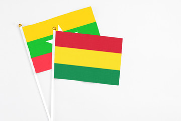 Bolivia and Myanmar stick flags on white background. High quality fabric, miniature national flag. Peaceful global concept.White floor for copy space.