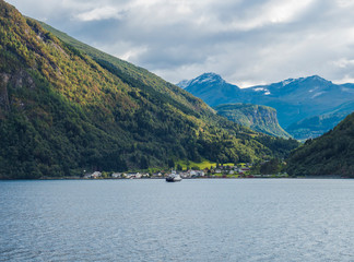 Beautiful Norwegian fjord. View across Storfjorden, towards village Eidsdal. Summer, blue sky. Norway