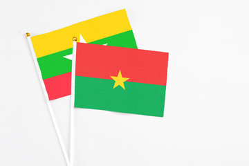 Burkina Faso and Myanmar stick flags on white background. High quality fabric, miniature national flag. Peaceful global concept.White floor for copy space.