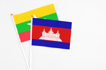 Cambodia and Myanmar stick flags on white background. High quality fabric, miniature national flag. Peaceful global concept.White floor for copy space.