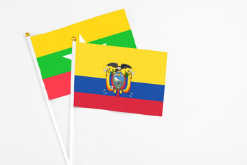 Fototapeta premium Ecuador and Myanmar stick flags on white background. High quality fabric, miniature national flag. Peaceful global concept.White floor for copy space.