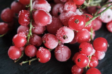 frozen berries red currants covered with hoarfrost scattered on a slate dish.
