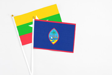 Guam and Myanmar stick flags on white background. High quality fabric, miniature national flag. Peaceful global concept.White floor for copy space.