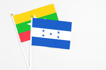 Honduras and Myanmar stick flags on white background. High quality fabric, miniature national flag. Peaceful global concept.White floor for copy space.