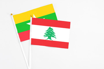 Lebanon and Myanmar stick flags on white background. High quality fabric, miniature national flag. Peaceful global concept.White floor for copy space.