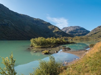 Milky blue glacial water of Lake Bovertunvatnet in the Jotunheimen National Park, Norway. Early autumn blue sky background.