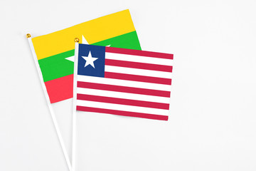 Liberia and Myanmar stick flags on white background. High quality fabric, miniature national flag. Peaceful global concept.White floor for copy space.